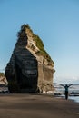 Woman on the beach next to a big rock formation known as one of the Royalty Free Stock Photo