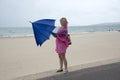 Woman on beach opening an umbrella Royalty Free Stock Photo