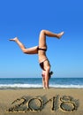 Woman on the beach by the sea while celebrating New Year 2018. Royalty Free Stock Photo