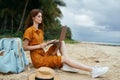 woman on the beach sitting on the sand tourism laptop technology travel