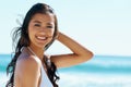 Woman, beach and smile in portrait with bikini in wind, holiday and face with pride in sunshine by ocean. Girl, person Royalty Free Stock Photo