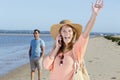 woman on beach on telephone calling and gesturing excitedly