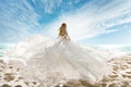 Woman on Beach in White Dress flying on Wind. Summer Vacation. Beach Sand Sea Sunshine Sky