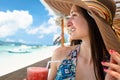 Woman in beachwear enjoying drink in beach cafe at sea
