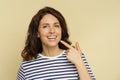 Woman with beaming smile point to white healthy teeth. Portrait of happy female with dental health Royalty Free Stock Photo