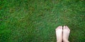 Woman bear feet standing on the lush fresh green grass lawn, top view, connect to nature power concept, receiving negative ions