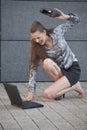 Woman beats laptop with shoe