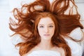 Woman with beautiful long red hair lying in bed Royalty Free Stock Photo