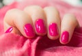 Woman with beautiful manicured pink fingernails gracefully crossing her hands to display them to the viewer on a white background Royalty Free Stock Photo