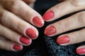 Woman with beautiful manicured red fingernails gracefully crossing her hands to display them to the viewer on a gray Royalty Free Stock Photo