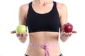 Woman with beautiful slender figure with centimeter at waist holds two red and green apples in hands closeup Royalty Free Stock Photo