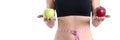 Woman with beautiful slender figure with centimeter at waist holds two red and green apples in hands closeup Royalty Free Stock Photo