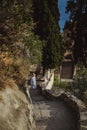 Woman in a beautiful summer dress and hat goes down the stairs to the observation deck in Castle Hill or Colline du Chateau park i