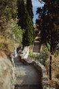 Woman in a beautiful summer dress and hat goes down the stairs to the observation deck in Castle Hill or Colline du Chateau park i