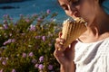 Woman beautiful summer time eat tasty ice cream in vaffle ocean sun blooming flower Royalty Free Stock Photo