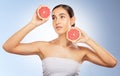 Woman, beauty and natural skincare with grapefruit, radiant glow and healthy aesthetic by blue background. Model, skin