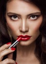 Woman Beauty Portrait with Red Lips Make up. Glamour Model applying Lipstick, Smokey Eyes. Professional Makeup Cosmetics Close up Royalty Free Stock Photo