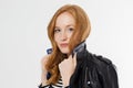 Woman beauty power. Close up of red haired girl face and leather jacket isolated on white background. Skin care, blue eyes