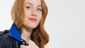 Woman beauty power. Close up of red haired girl face, leather jacket on white background. Skin care, blue eyes