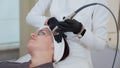 Using YAG laser for facial skin therapy at cosmetology clinic