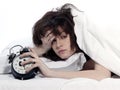 Woman In Bed Awakening Tired Holding Alarm Clock