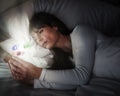 Woman in bed being absorbed by her mobile phone