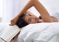 Woman, bed and book portrait in the morning with reading and relax in a home with a smile. Indian female person, bedroom