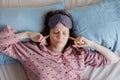 woman in bed wakes up, insomnia and sleep disorder. person in sleep mask holds his head and face Royalty Free Stock Photo