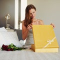 Woman, bedroom and open box with roses, present and happy for surprise on birthday, valentines day and event. Girl