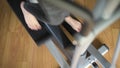 A woman begins and ends training on an ellipsoid. Close-up top view of the legs on the pedals
