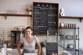 Woman behind the counter of a coffee shop looking to camera Royalty Free Stock Photo