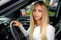 Woman behind wheels - Smiling young woman looking out of car window Royalty Free Stock Photo