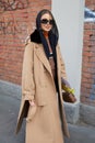 Woman with beige coat and brown trousers before Fendi fashion show, Milan Fashion Week street Royalty Free Stock Photo