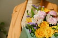 A woman in a beige coat holds a beautiful autumn bouquet in her hands. Depersonalization concept. Close up