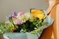 A woman in a beige coat holds a beautiful autumn bouquet in her hands. Depersonalization concept. Close up