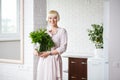 Woman in a beige dress with a bouquet of mint in hand, standing Royalty Free Stock Photo