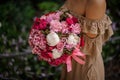 Woman in beige dress holding a romantic bouquet of flowers in pink tones Royalty Free Stock Photo