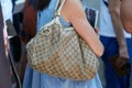 Woman with beige Gucci bag and blue dress before Fendi fashion show, Milan Fashion Week street style on June 18,