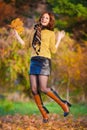 Woman in beige sweater and black leather skirt jump