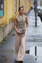 Woman with beige trousers and grey green bag before Tods fashion show, Milan Fashion Week