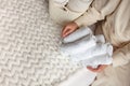 Woman in beige warm robe is folding the clean white hand towels and putting into a metal mesh basket. Topview. Royalty Free Stock Photo