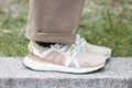 Woman with beige, white and golden sneakers before Giorgio Armani fashion show, Milan Fashion Week street