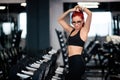 Portrait of fit woman being happy and smiling at gym. Fitness woman getting ready for high intensity training, workout