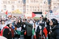 Toronto, Canada - 28 October 2023: A woman is being interviewed amidst a crowd of protestors in front of a historic