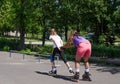 Woman being pulled along by a young roller skater Royalty Free Stock Photo