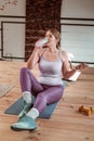 Smiling beaming lady carrying matte bottle with clear water