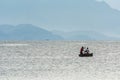 Woman being transported by a man on a small rowing canoe