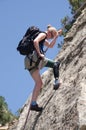 Woman belaying on rock face with prosthetic leg.