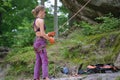 Woman belays her partner climber with belaying device and rope. Climber`s helper holding equipment for rock mountaineering