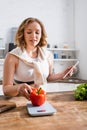 Woman bell pepper on kitchen scales